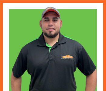 SERVPRO employee in front of green wall